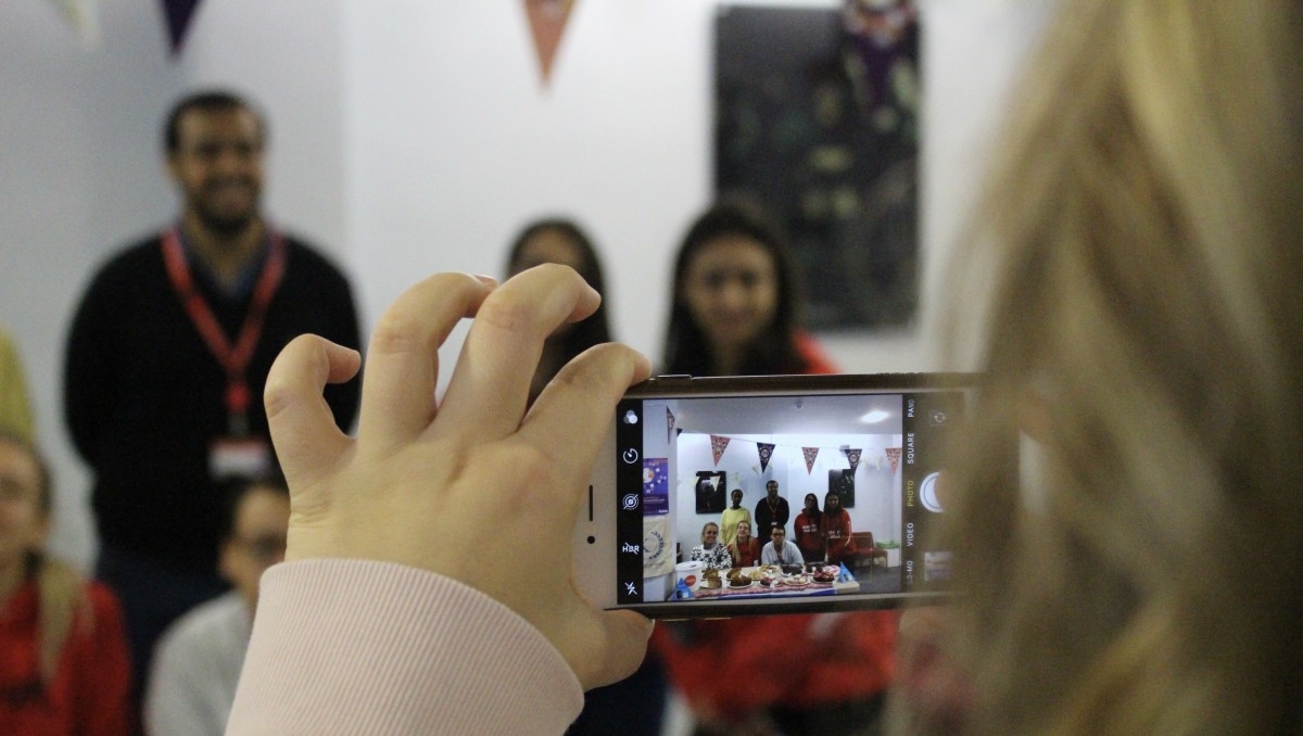 Student taking photo of a student society with a phone
